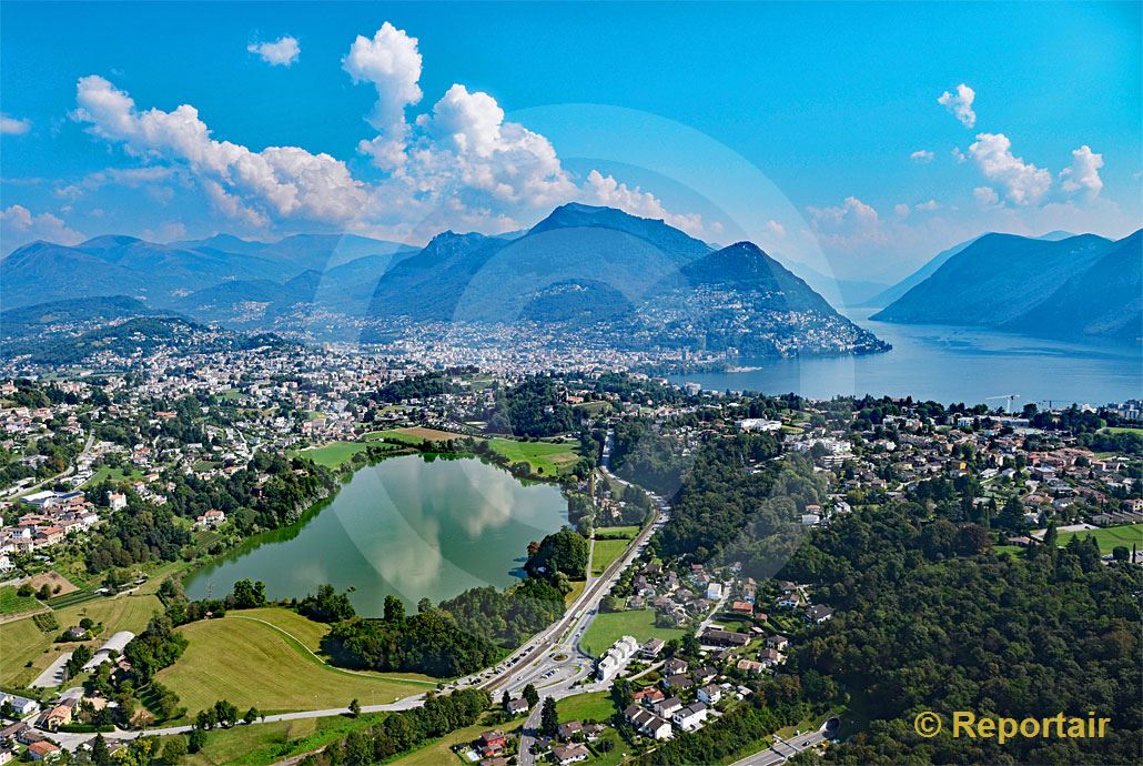Foto: Der Lago di Muzzano mit Lugano TI im Hintergrund. (Luftaufnahme von Niklaus Wächter)