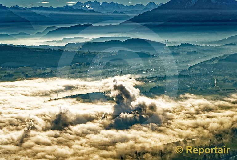 Foto: Hochnebel, Dunst und die qualmenden Kamine der Papierfabrik Perlen sorgen für eine dramatische Stimmung bei Luzern. (Luftaufnahme von Niklaus Wächter)